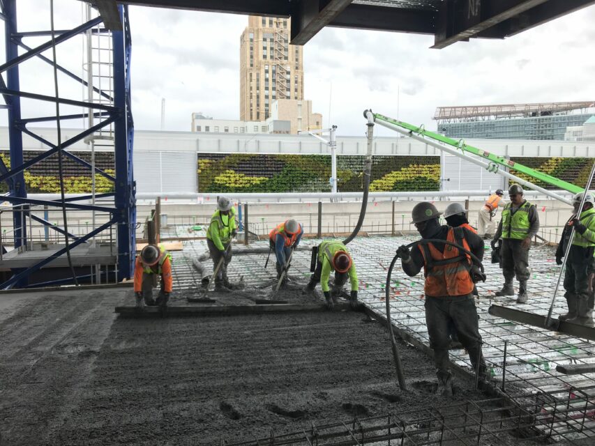 A construction crew pours low carbon concrete