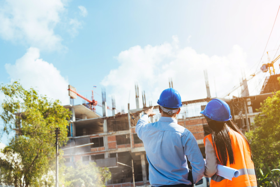 Civil Engineer And Architect Wearing Blue Safety Helmet Meeting At Contruction Site